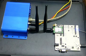 一台带两根天线的 MultiTech Conduit LoRaWAN 网关，旁边是一块 LoRa 节点板